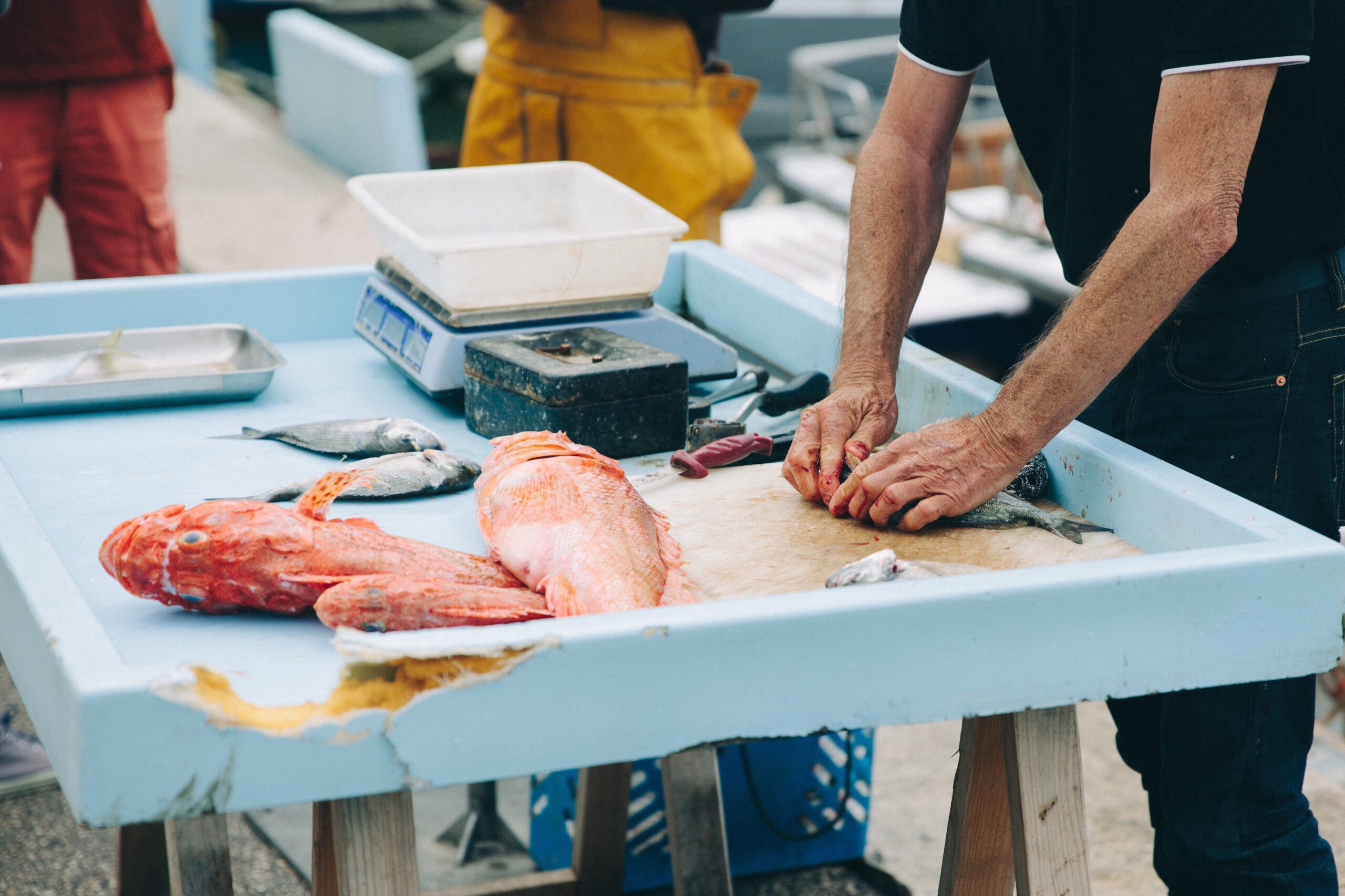 man-slicing-fishes-market-stall